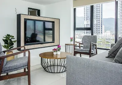 a living room with a large flat screen tv at Rumahku Gurney with 270 degree Sea View in George Town