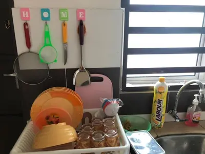 a kitchen counter with a sink with dishes and utensils at Hasnifana Homestay Seri Iskandar in Seri Iskandar