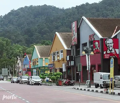 a town with cars parked on the side of a street at Dindings Pantai Desair Apartment By DPD in Lumut