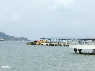a dock in the water with boats in the water at Dindings Pantai Desair Apartment By DPD in Lumut