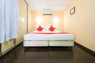 a bedroom with a bed with two red pillows at Hotel O Ombak Inn Chalet in Pangkor
