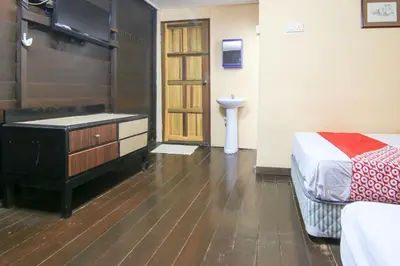 a bedroom with a bed and a dresser and a television at Hotel O Ombak Inn Chalet in Pangkor