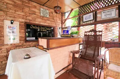 a restaurant with a table and a chair in a room at Hotel O Ombak Inn Chalet in Pangkor