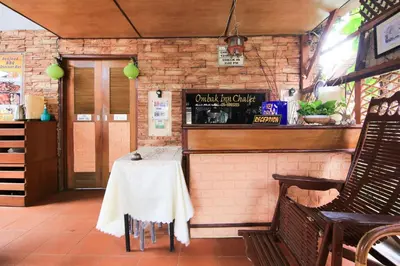 a dining area with a table and chairs in a restaurant at Hotel O Ombak Inn Chalet in Pangkor