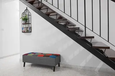 a couch sitting under a stairs with a stair case at Ipoh Garden Homestay in Ipoh