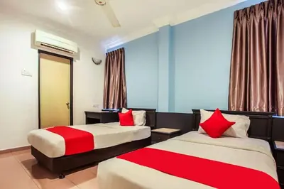 a hotel room with two beds with red pillows at Hotel Home 88 in Teluk Intan