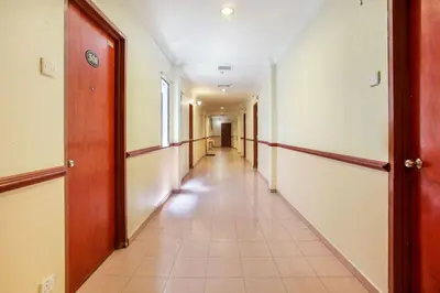 an empty hallway with a long corridor in a building at Hotel Home 88 in Teluk Intan