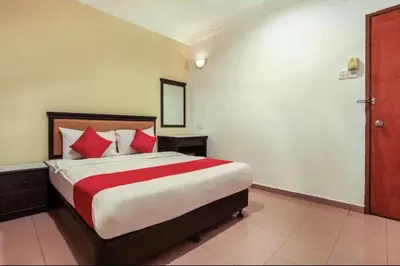 a bedroom with a large bed with red pillows at Hotel Home 88 in Teluk Intan