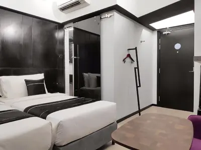 a bedroom with two beds and a table in it at Loop On Leith George Town Penang Hotel in George Town