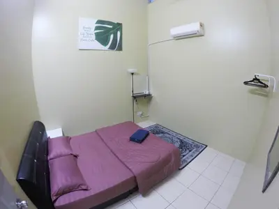 a small bedroom with a purple bed in a room at D HOMESTAY SERI ISKANDAR in Seri Iskandar