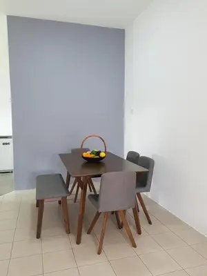 a table with chairs and a bowl of fruit on it at PINKY VILLA in Ipoh
