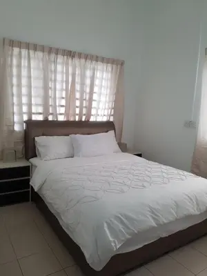 a bedroom with a bed with white sheets and a window at PINKY VILLA in Ipoh