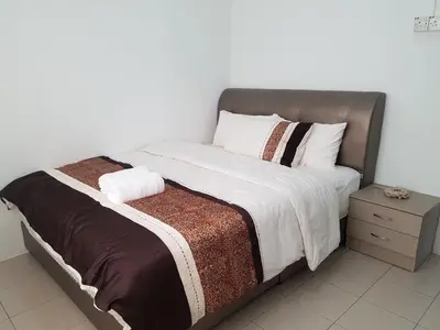 a bedroom with a large bed with a brown headboard at PINKY VILLA in Ipoh