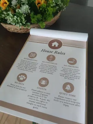 a sign on a table with a basket of flowers at PINKY VILLA in Ipoh