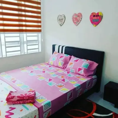 a bedroom with a pink bed with hearts on the wall at Nur Zahra Sungkai Homestay in Sungkai