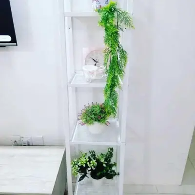 a white shelf with plants on it at Nur Zahra Sungkai Homestay in Sungkai