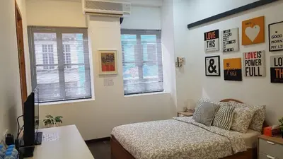 a bedroom with a bed and two windows at Rooms only @KKB in Kuala Kubu Baharu