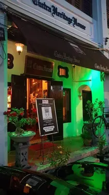 a green building with a sign in front of it at Cintra House in George Town