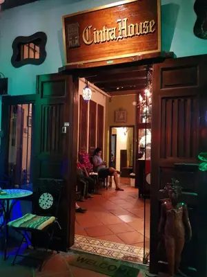 a woman sitting at a table in a restaurant at Cintra House in George Town
