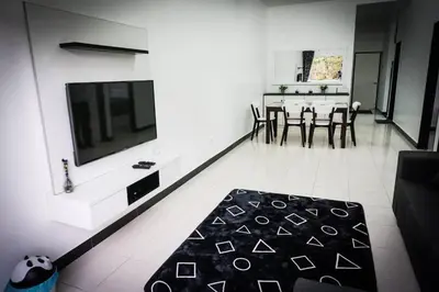 a living room with a tv and a table and chairs at 80'S PARADISE in Tanah Rata
