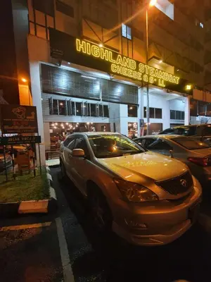 a car parked in a parking lot in front of a store at 80'S PARADISE in Tanah Rata