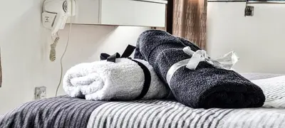 a bedroom with a bed with black and white towels at 80'S PARADISE in Tanah Rata