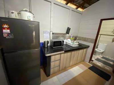 a kitchen with a microwave and a refrigerator at Rustic Chalet - Dahlia n Mawar at Sedim Vista in Kampong Ulu Sedim