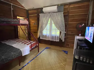 a bedroom with a bunk bed and a tv and a window at Rustic Chalet - Dahlia n Mawar at Sedim Vista in Kampong Ulu Sedim
