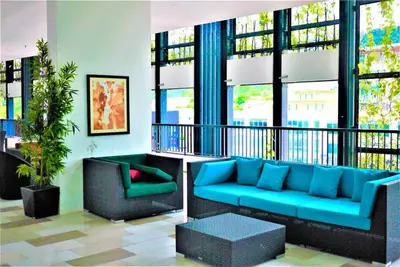 a living room with a blue couch and a chair at Seaview Landmark Studio Homestay at Gurney \u65e0\u654c\u6d77\u666f\u5957\u623f in Tanjong Tokong