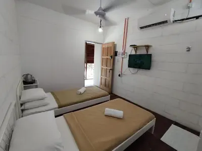 a room with two beds and a tv in it at MyDusun Chalet, Taiping, Perak, Malaysia in Taiping