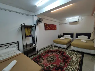 a room with two beds and a rug at MyDusun Chalet, Taiping, Perak, Malaysia in Taiping