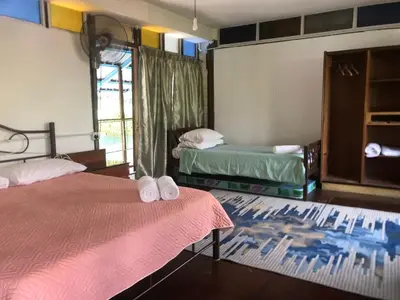 a room with two beds with towels on them at MyDusun Chalet, Taiping, Perak, Malaysia in Taiping