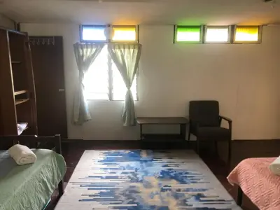 a room with a bed and a table and a window at MyDusun Chalet, Taiping, Perak, Malaysia in Taiping