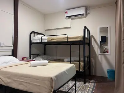 a room with two bunk beds and a air conditioner at MyDusun Chalet, Taiping, Perak, Malaysia in Taiping