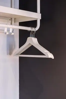 a white hanger hanging from a white shelf at Georgetown Tropicana 218 by Airlevate Suites in George Town
