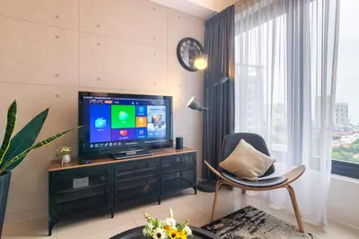 a living room with a tv and a chair at Georgetown Tropicana 218 by Airlevate Suites in George Town