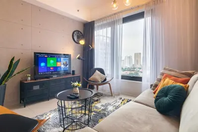 a living room with a couch and a tv at Georgetown Tropicana 218 by Airlevate Suites in George Town