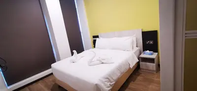 a bedroom with a bed with white shoes on it at TT Dorf Hotel Taiping in Taiping