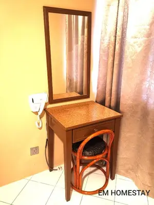 a table with a mirror and a chair under it at EM HOMESTAY(Coral Bay 3Room Apartment) in Pangkor