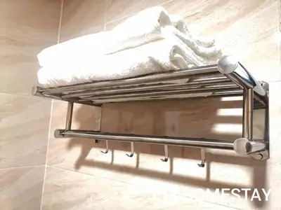 a towel rack on a bathroom floor with towels at EM HOMESTAY(Coral Bay 3Room Apartment) in Pangkor