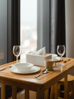 a wooden table with two glasses and a plate at Muji Studio 1 - Seaview at 218 Tropicana Near Komtar Food Heaven with Netflix & TV Box in George Town