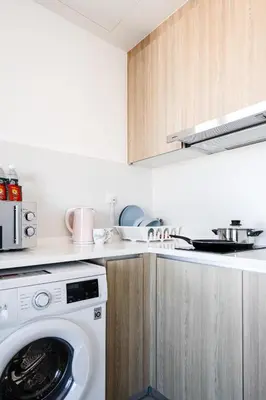 a kitchen with a washing machine in a kitchen at De Pastel Studio - SeaView at 218 Tropicana NEAR Komtar Food Heaven with Netflix & TV Box in George Town