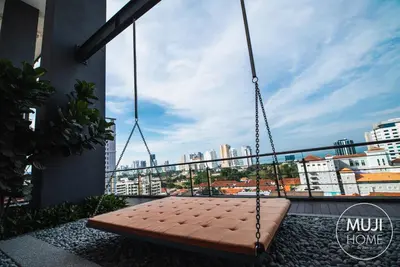 a swing on a balcony with a view of a city at De Pastel Studio - SeaView at 218 Tropicana NEAR Komtar Food Heaven with Netflix & TV Box in George Town