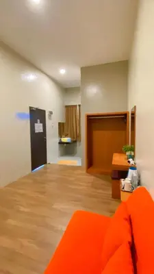 a living room with an orange couch in a room at DURIAN HILL VILLA in Gua Musang