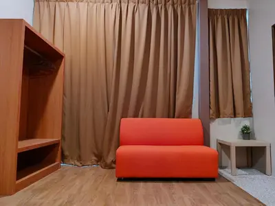 a red chair sitting in front of a curtain at DURIAN HILL VILLA in Gua Musang