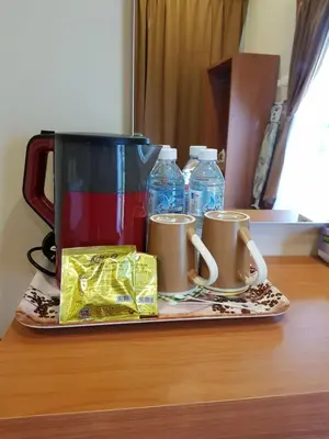 a table with two coffee mugs and water bottles at DURIAN HILL VILLA in Gua Musang