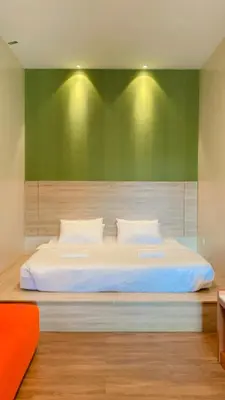 a bedroom with a large bed with a green wall at DURIAN HILL VILLA in Gua Musang
