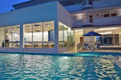 a house with a swimming pool in front of a house at AVI Pangkor Beach Resort in Pangkor