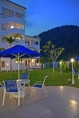 a patio with a table and chairs and an umbrella at AVI Pangkor Beach Resort in Pangkor