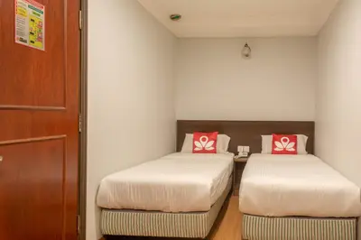 two beds in a small room with red pillows at Hotel Rose Crest Hill, Cameron Highlands in Cameron Highlands